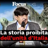 Gianni Oliva parla della storia proibita dell'unità d'Italia, con un campanile e un monumento equestre sullo sfondo.