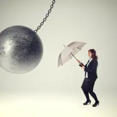 Donna con ombrello si prepara ad affrontare una palla da demolizione, come se il re è nudo e lei fosse l'unica a vederlo.