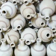 Un mucchio di giarre in terracotta, ognuna con un'ansa e due bocche, decorate con sottili linee marroni. Queste giarre, con il loro **giara significato** di contenimento e tradizione, creano un pattern visivo affascinante.