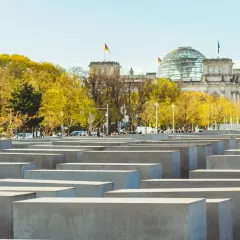 Il memoriale dell'Olocausto di Berlino, con le sue stele di cemento e il Reichstag sullo sfondo, evoca un profondo ricordo.