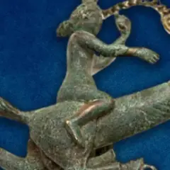 Antica statuetta in bronzo di un cavaliere che cavalca un cavallo, forse un **fallo dio pan** in movimento.