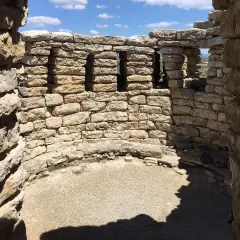 Interno del nuraghe Su Mulinu, con mura in pietra grezza e finestre quadrate che si affacciano sul paesaggio.