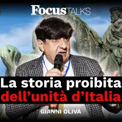 Gianni Oliva parla della storia proibita dell'unità d'Italia, con un campanile e un monumento equestre sullo sfondo.