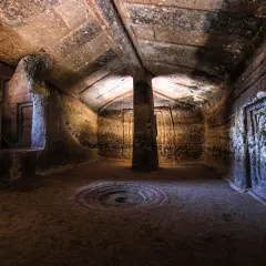 Interno di una domus de janas a Putifigari, con pilastro centrale e decorazioni scolpite.