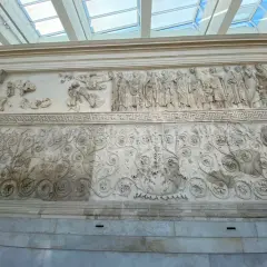 Rilievi dell'Ara Pacis: una processione di figure e decorazioni floreali intricate, testimonianza dell'arte romana.