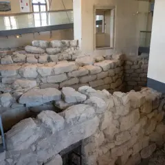 Interno del nuraghe di Barumini, con antiche mura in pietra e reperti archeologici esposti.