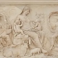 Rilievo esterno dell'Ara Pacis: una madre con due bambini, affiancata da figure femminili con cigno e creatura marina, circondata da animali e vegetazione.