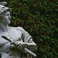 Statua di Hermes con elmo alato e spada, simbolo di messaggero e commercio. Il suo significato è legato alla velocità e all'ingegno.