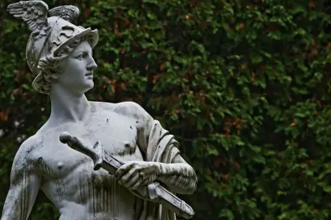 Statua di Hermes con elmo alato e spada, simbolo di messaggero e commercio. Il suo significato è legato alla velocità e all'ingegno.