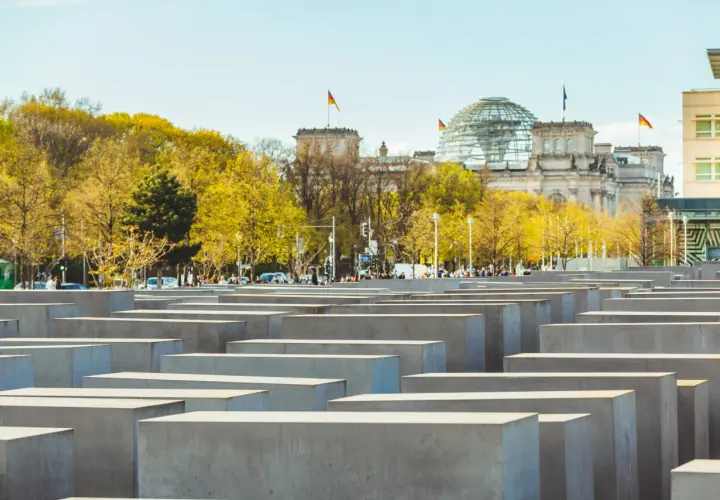 Il memoriale dell'Olocausto di Berlino, con le sue stele di cemento e il Reichstag sullo sfondo, evoca un profondo ricordo.