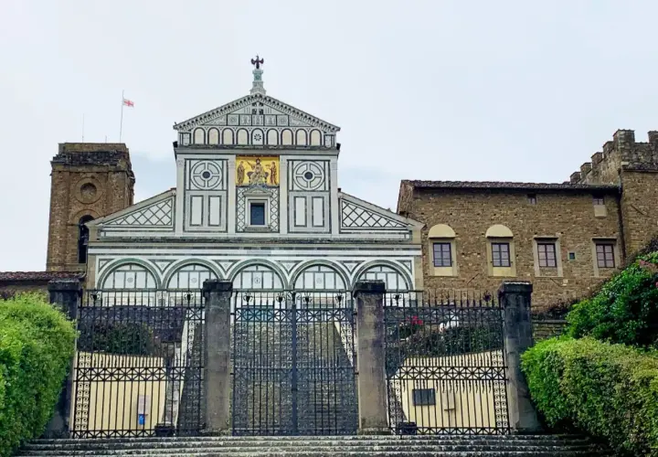 La Basilica di San Miniato al Monte a Firenze, con la sua facciata marmorea e il campanile, domina la città.