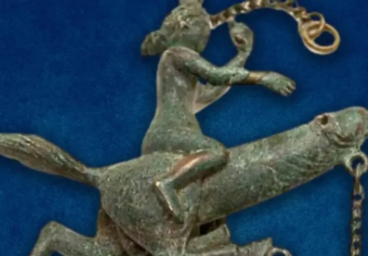 Antica statuetta in bronzo di un cavaliere che cavalca un cavallo, forse un **fallo dio pan** in movimento.