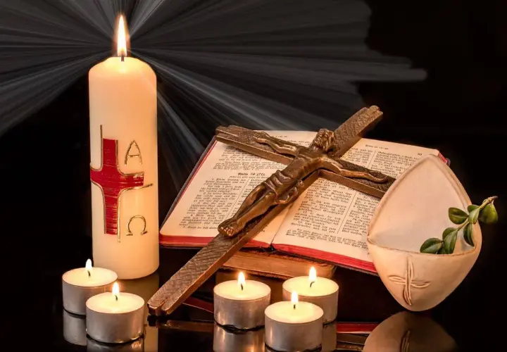 Candela pasquale, croce, Bibbia e lumini creano un'atmosfera solenne, evocando il significato della festa mobile.