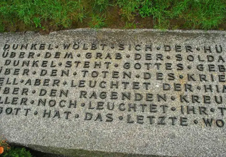 Dettaglio di un'iscrizione in tedesco su una lapide in un cimitero tedesco in Normandia. Le parole evocano oscurità e speranza.