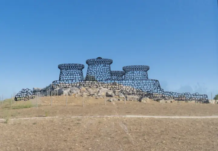 Disegno stilizzato del nuraghe Genna Maria, con torri tronche e mura merlate, su uno sfondo di cielo azzurro e terreno brullo.