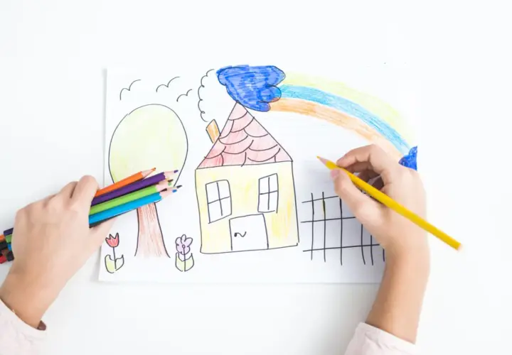 Bambino colora un disegno con matite, creando una casa, un albero e un arcobaleno. La dea Ebe, simbolo di giovinezza, ispira la creatività.
