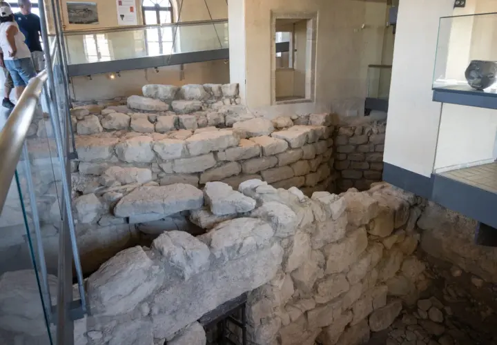 Interno del nuraghe di Barumini, con antiche mura in pietra e reperti archeologici esposti.