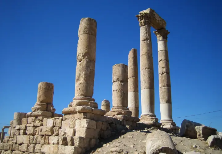 Antiche colonne di pietra si ergono contro un cielo blu intenso, evocando il **colonne d'ercole significato** di confini e meraviglie antiche.
