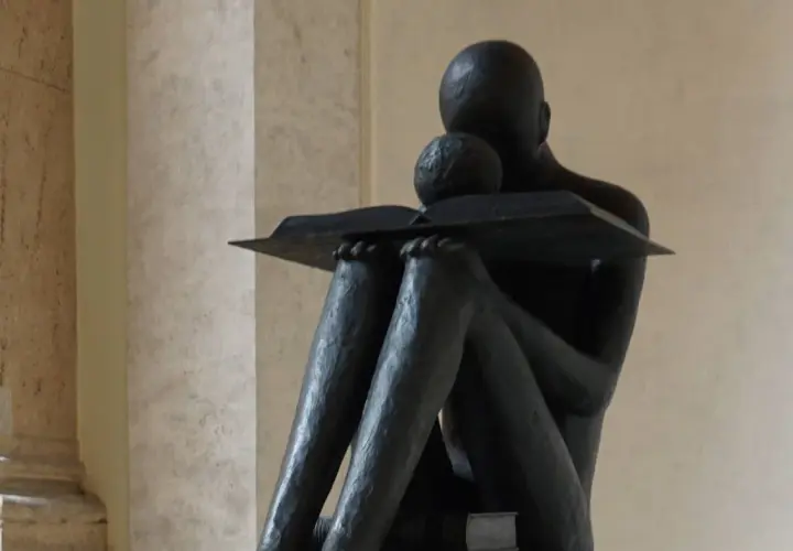 Statua di una figura che legge, immersa in un momento di riflessione, quasi un sinonimo di accidia intellettuale.