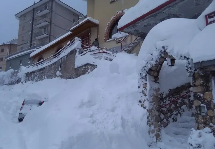 Neve alta a Scanno, quasi sepolta un'auto. L'arco in pietra, forse l'ingresso alla grotta dei colombi, è coperto di neve.