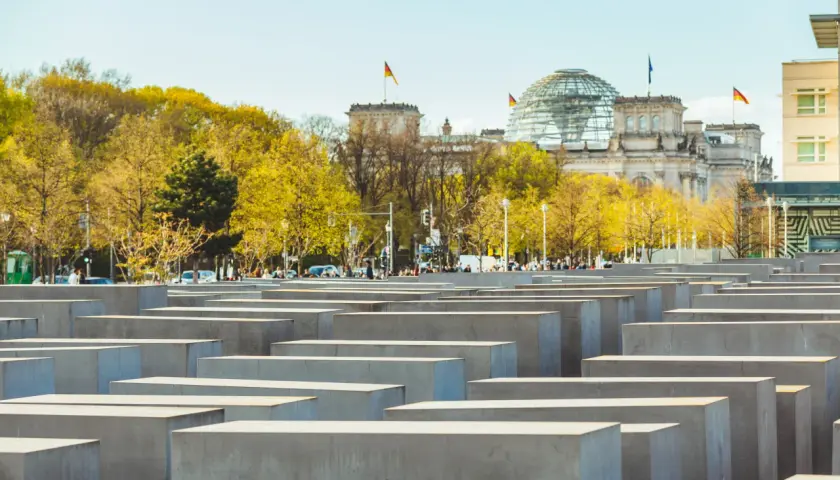 Il memoriale dell'Olocausto di Berlino, con le sue stele di cemento e il Reichstag sullo sfondo, evoca un profondo ricordo.