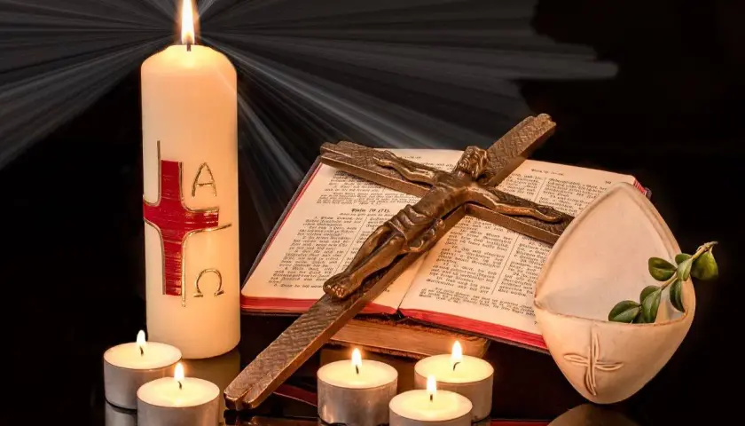 Candela pasquale, croce, Bibbia e lumini creano un'atmosfera solenne, evocando il significato della festa mobile.