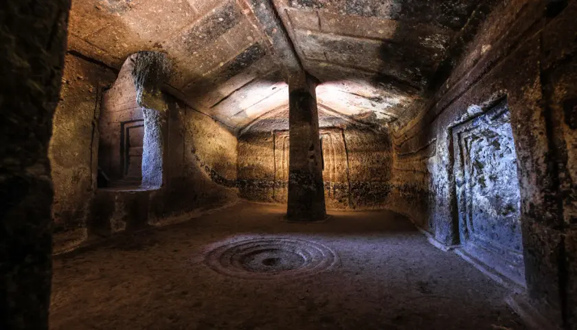 Interno di una domus de janas a Putifigari, con pilastro centrale e decorazioni scolpite.