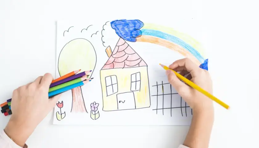Bambino colora un disegno con matite, creando una casa, un albero e un arcobaleno. La dea Ebe, simbolo di giovinezza, ispira la creatività.