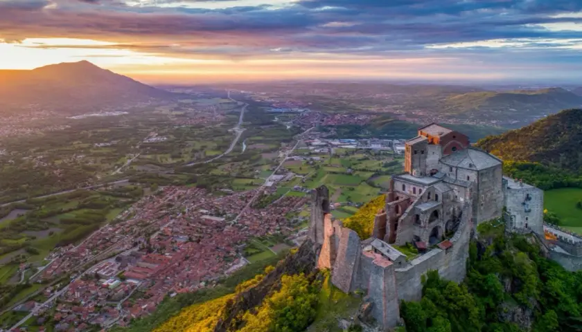 Sacra di San Michele, punto focale della linea di San Michele significato esoterico, domina la valle al tramonto.