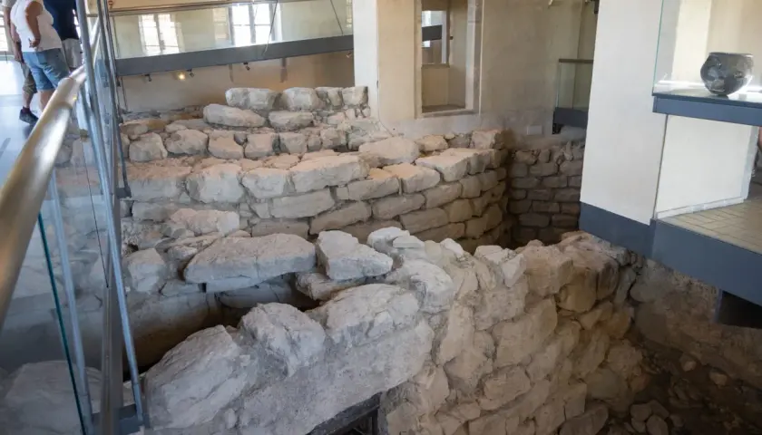 Interno del nuraghe di Barumini, con antiche mura in pietra e reperti archeologici esposti.