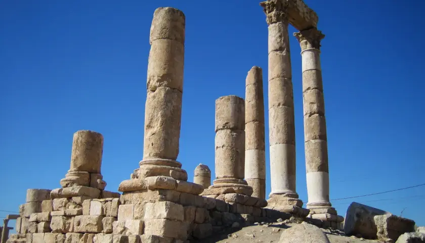 Antiche colonne di pietra si ergono contro un cielo blu intenso, evocando il **colonne d'ercole significato** di confini e meraviglie antiche.