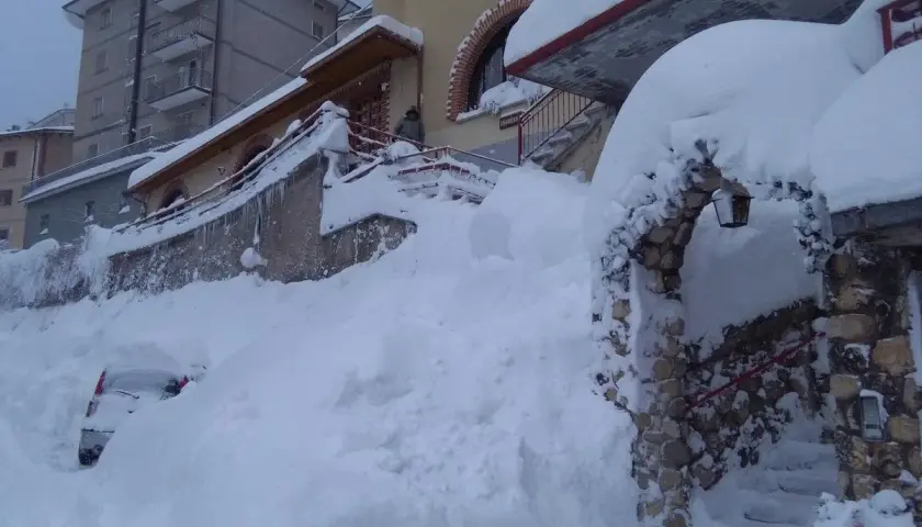 Neve alta a Scanno, quasi sepolta un'auto. L'arco in pietra, forse l'ingresso alla grotta dei colombi, è coperto di neve.