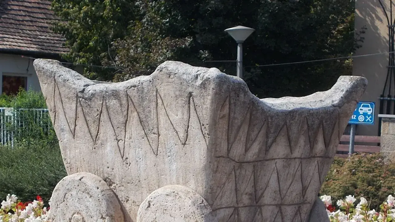 Scultura in pietra di un carro antico, con decorazioni a zig-zag. Chissà chi ha inventato la ruota per creare un mezzo così.