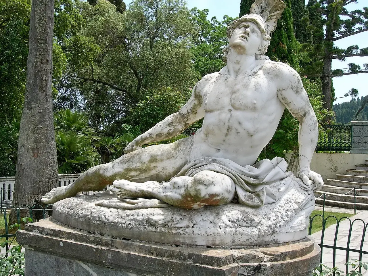 Statua di Achille, eroe greco o acheo, disteso in un giardino lussureggiante.