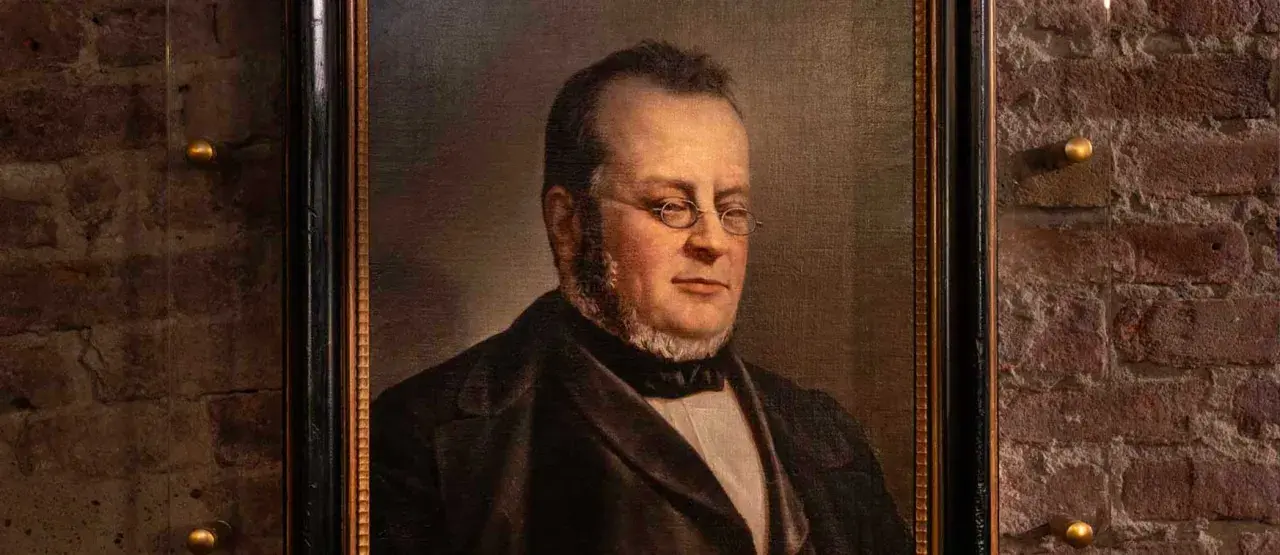 Ritratto di Michele Benso di Cavour, con occhiali tondi e barba curata, vestito elegantemente.