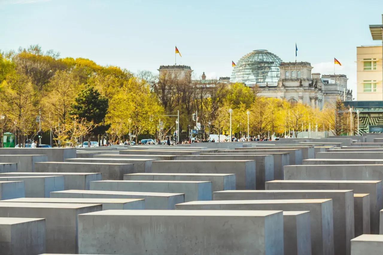 Il memoriale dell'Olocausto di Berlino, con le sue stele di cemento e il Reichstag sullo sfondo, evoca un profondo ricordo.