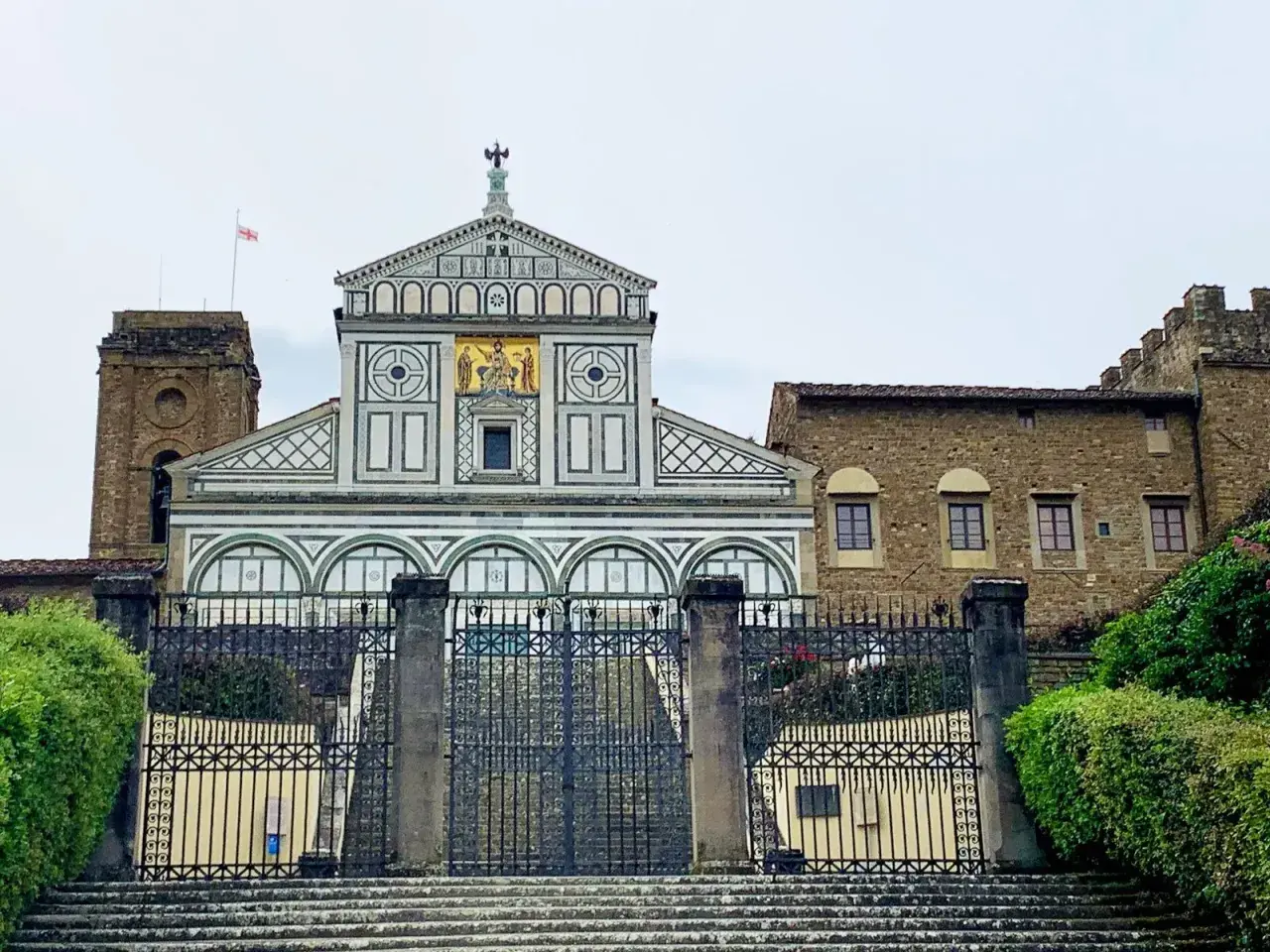 La Basilica di San Miniato al Monte a Firenze, con la sua facciata marmorea e il campanile, domina la città.