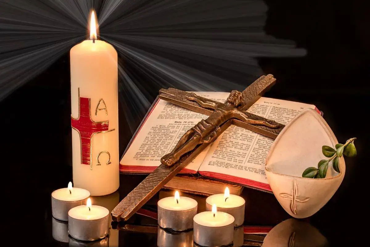 Candela pasquale, croce, Bibbia e lumini creano un'atmosfera solenne, evocando il significato della festa mobile.
