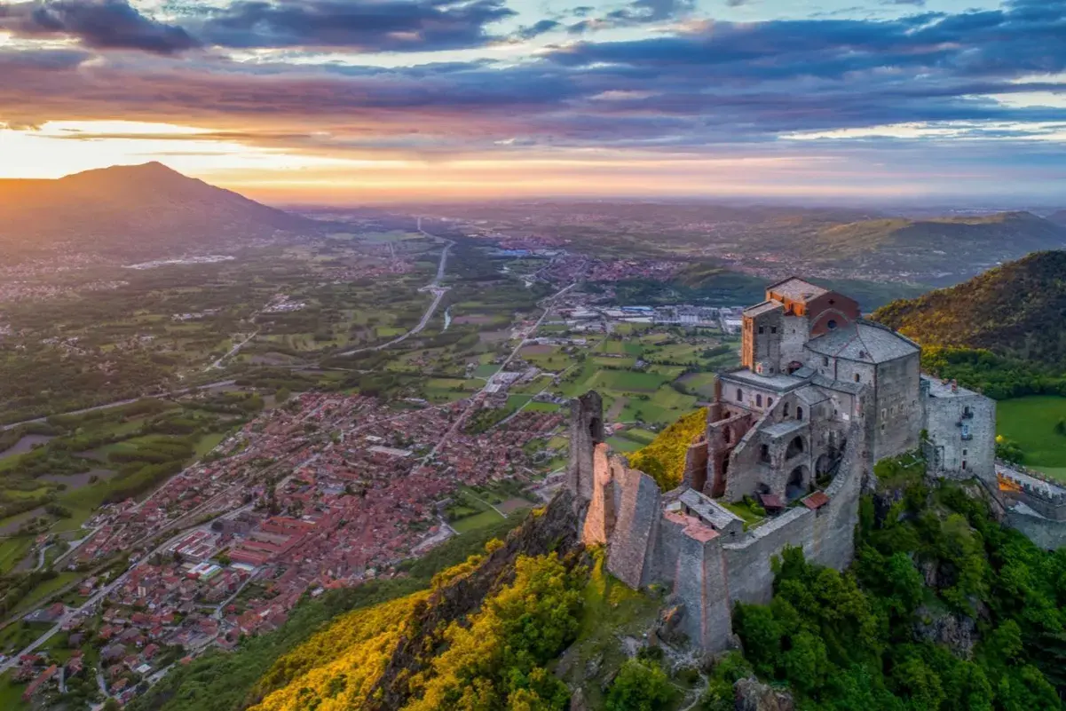 Sacra di San Michele, punto focale della linea di San Michele significato esoterico, domina la valle al tramonto.