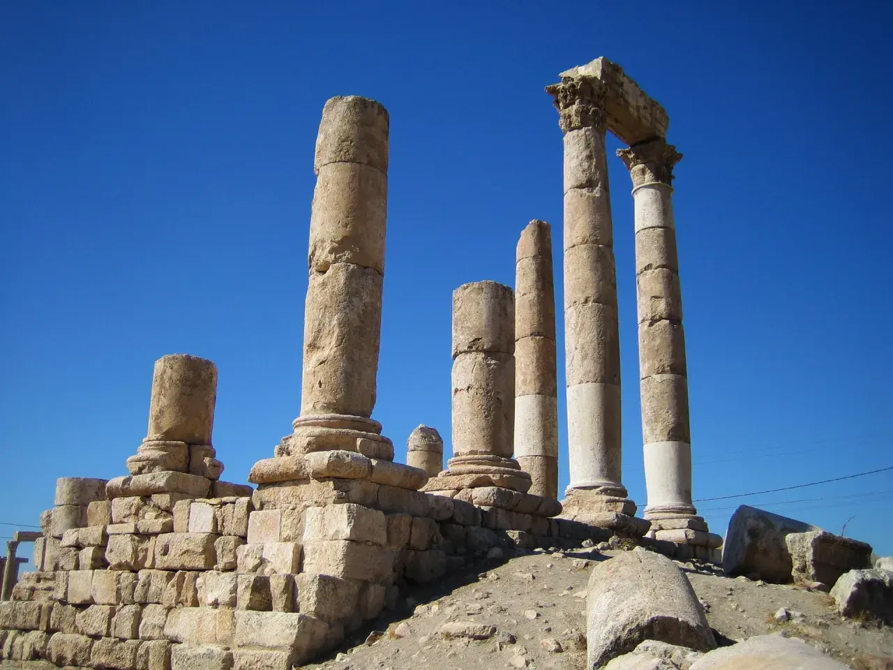 Antiche colonne di pietra si ergono contro un cielo blu intenso, evocando il **colonne d'ercole significato** di confini e meraviglie antiche.