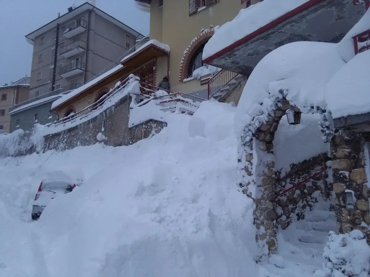 Neve alta a Scanno, quasi sepolta un'auto. L'arco in pietra, forse l'ingresso alla grotta dei colombi, è coperto di neve.