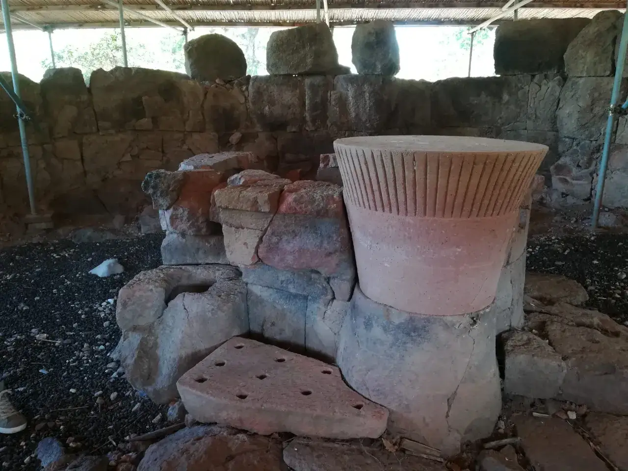 Antichi reperti archeologici, tra cui un grande cono di pietra scanalato, frammenti di vasche e una lastra forata, testimoniano la storia dei pozzi sacri in Sardegna.