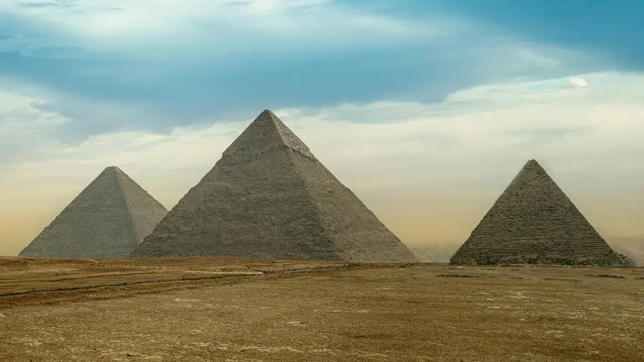 Le piramidi di Giza, monumenti eterni che custodiscono i segreti del nome di 11 faraoni, si stagliano contro un cielo nuvoloso.