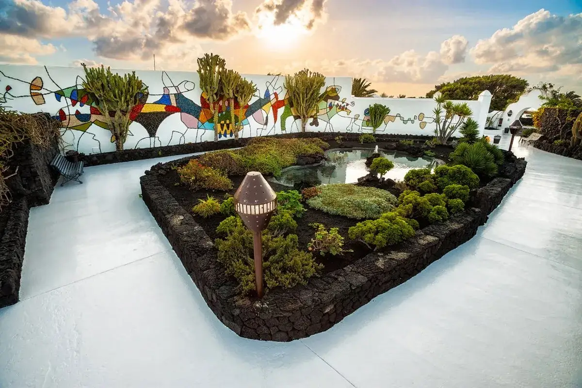 Giardino con laghetto e scultura murale colorata, un angolo di pace che riflette la creativit&agrave; di C&eacute;sar Manrique e la sua vita privata.