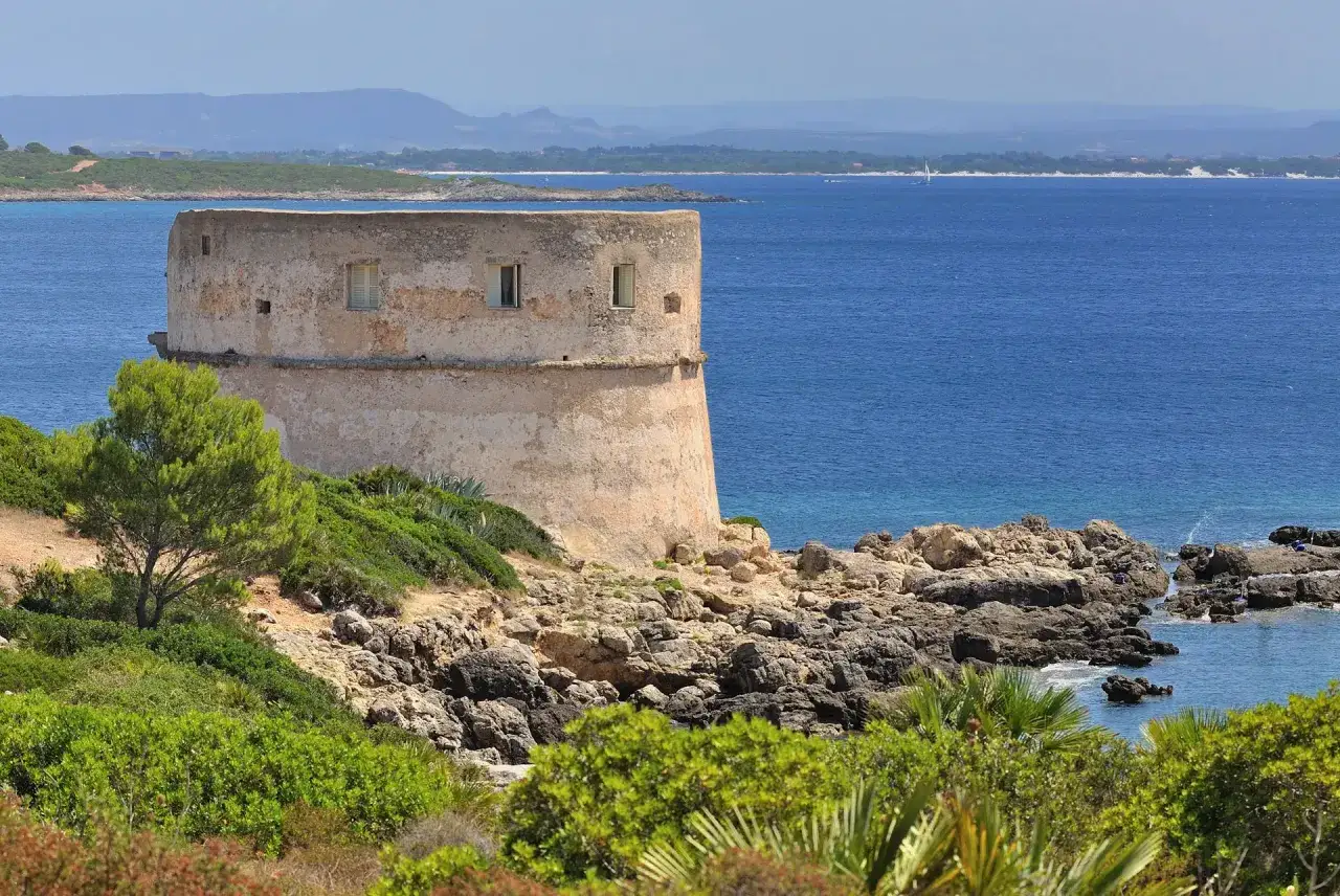 Torre costiera sarda, un tempo avamposto contro i pirati sardi, domina il mare blu.