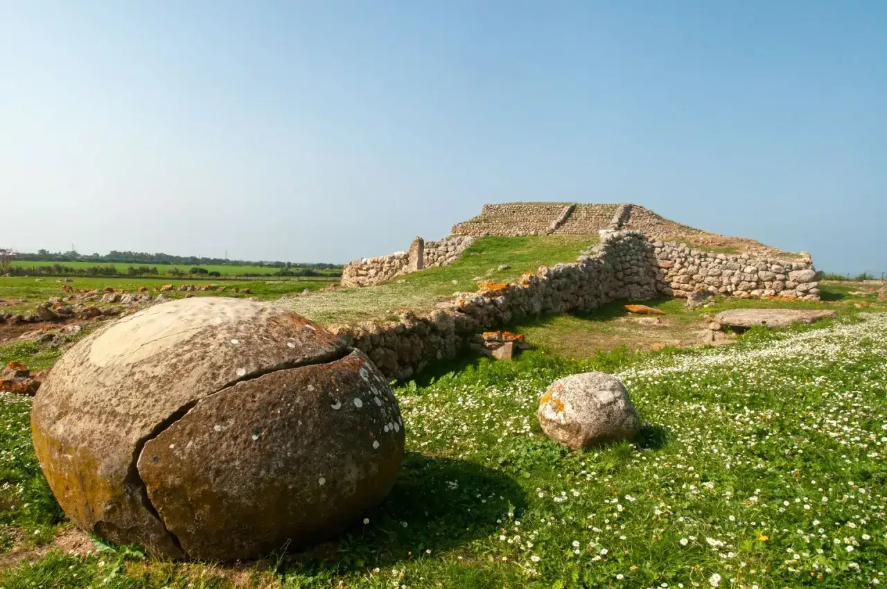 Antiche pietre e un paesaggio verdeggiante ricordano un antico ziqqurat in Sardegna.