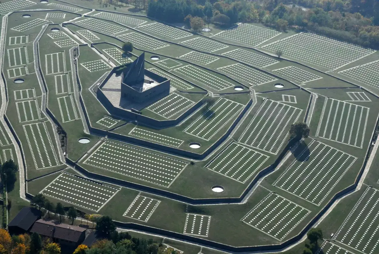 Vasta distesa di tombe ordinate, con un imponente monumento centrale. Il cimitero tedesco del Passo della Futa, un luogo di memoria.