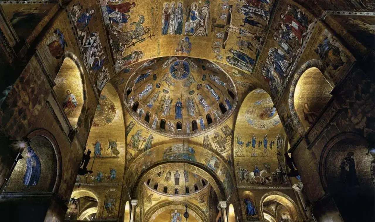 Interno dorato della cripta di San Marco, con mosaici bizantini che narrano storie sacre su cupole e volte.