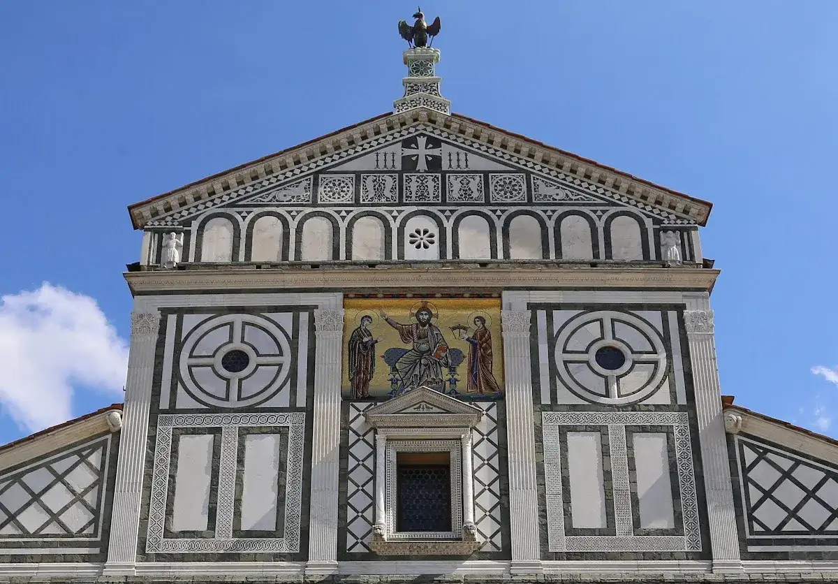 Facciata di San Miniato a Firenze con mosaico di Cristo in trono e decorazioni geometriche.